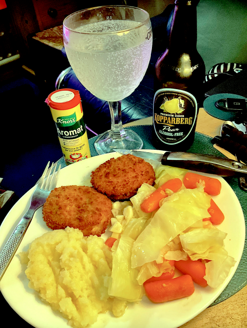 Two Chicken Kievs with potatoes, cabbage and carrots.